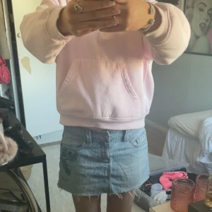 Jeanskjol med broderi - Säljer en snygg jeanskjol med broderade detaljer på bakfickorna. Kjolen har en klassisk blå denimfärg och en kort längd som passar perfekt för varmare dagar.