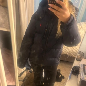 Mörkblå dunjacka från Ralph Lauren - Säljer denna fina Ralph loren jacka i M. Den är i väldigt bra skick bara använd några gånger. Säljer då den är för stor för mig