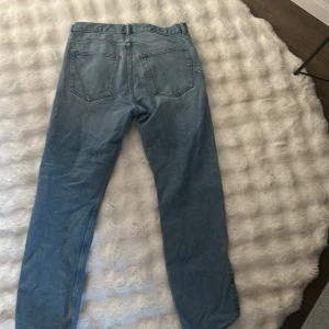 Arket ocean jeans 100% cotton - Klassiska arket jeans i ljusblå denim med raka ben och normal passform. Femficksmodell med knappgylf och tydliga sömmar. Perfekta för dig som gillar en tidlös och avslappnad look. 