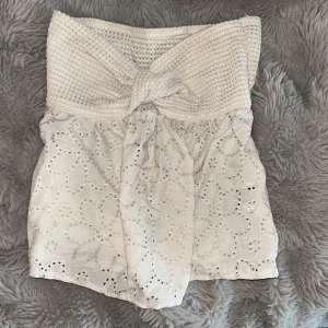 Topp - Fin ljusbeige topp med stickat knyte upptill och ett blommigt mönster nedtill. Jättesöt och fin till sommaren