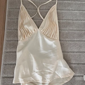 Champagnefärgad linnetopp i satin - Supersnygg linnetopp i champagnefärgad satin!