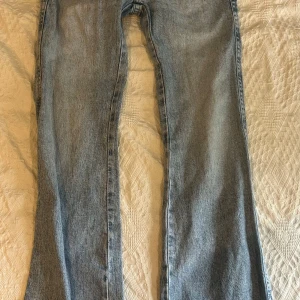 Perfekt lågmidjade bootcut jeans från Gina Tricot  - Säljer dessa ljusblåa lågmidjade bootcut (perfekt jeans) från Gina Tricot med dubbla knappar och detaljerade fickor. Liten defekt längst ner (nedtrampat), men inget som syns! Stl 34, säljer även fler par jeans! Kolla gärna i profil💕
