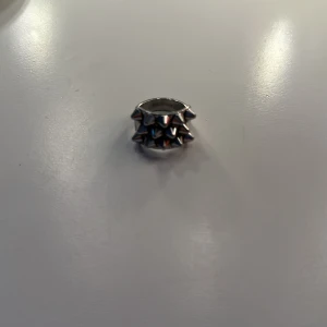 Bred silverring med nitar - Cool bred ring i silverfärg med två rader av små, spetsiga nitar runt hela ringen. Perfekt statement-piece för dig som gillar edgy och unik stil. Ringen är i metall och har en riktigt tuff vibe.