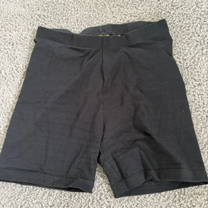 Svarta cykelshorts i bomull - Svarta, enkla cykelshorts i mjuk bomull med stretch. Perfekta för träning eller som basplagg under kjol eller klänning. Klassisk midja och tight passform som sitter skönt hela dagen.