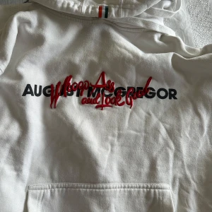 Vit hoodie från August McGregor  - Limited edition vit hoodie från August McGregor med svart och röd text på bröstet: 'Whoop Ass and Look Good'. Är ett samarbete mellan David August och Conor McGregor. Denna hoodie såldes år 2018 om jag inte minns fel. Har använts extremt sällan och är för liten på mig. 