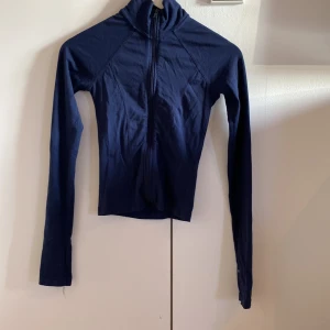 Mörkblå ziptröja från Gina Tricot  - Mörkblå långärmad ziptröja från Gina Tricot i storlek XS. Tröjan har en smal passform, hög krage och hel dragkedja framtill. (Fläck på höger ärm)💙