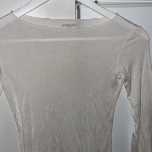 Vit tunn långärmad topp  - Säljer en tunn, vit långärmad topp  i storlek XS. (Intimisdupe)Modellen är figurnära med rund halsringning och tillverkad i ett mjukt, lätt material som känns skönt mot huden. 