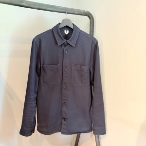 Overshirt från Arket - Stilren overshirt från Arket i en klassisk blå färg. Håller bra skick, inga synliga defekter. Nypris är 790 kr.