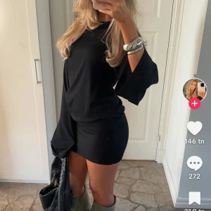Effortless structure dress Nelly  - Supersnygg svart kortklänning från Nelly med offshoulder och vida långa ärmar. Klänningen har en tight passform nertill och lösare upptill, vilket ger en cool och trendig look. Perfekt för dig som gillar stilrena och moderna plagg. Den e helt nya vill dock byta till storlek S 