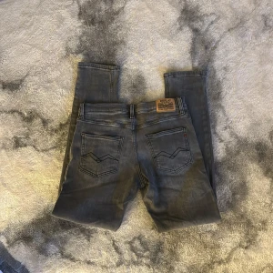 Grå skinny jeans från Replay - Snygga grå jeans från Replay med klassisk femficksdesign och diskreta detaljer. Jeansen har smal passform och raka ben, perfekt för en clean och modern look. Tillverkade i mjukt jeanstyg som sitter skönt hela dagen.