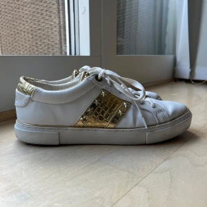 Guess skor - Vita skor från Guess med gulddetaljer! Nypris ca 1400kr