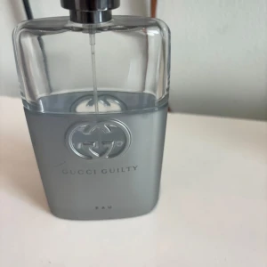 Gucci Guilty Eau parfym (tom flaska) - Gucci Guilty Eau parfym i en stilren, rektangulär flaska med silvergrått glas och metallisk logotyp på framsidan. Flaskan har en modern och lyxig känsla, perfekt för dig som gillar exklusiva dofter och snygg design på parfymhyllan.