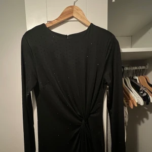 Svart glittrig klänning från H&M - Snygg svart långärmad klänning från H&M, använd endast 1 gång, kan gå ner i pris