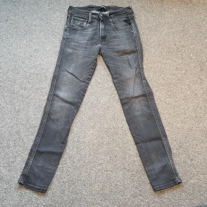 Replay jeans - Replay jeans av storlek W29 L30. Modellen är skinny så skulle säga att den passar W27 W28. Skicket på dessa gråa jeans är 8/10. På knappen längst fram samt de valentino liknande spikarna på jeansen har tappat en del färg, det märks dock inte på knappen. Dessa jeans har inga hål eller skador. Jeansen är handgjorda i Italien och är av märket Replay. Ny pris 1 800kr!
