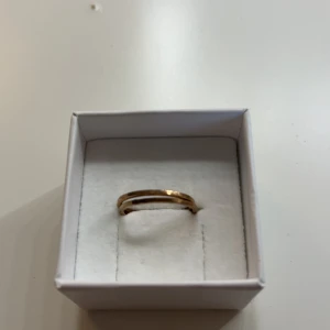 Dubbel guld ring i minimalistisk stil - Snygg och stilren ring i guld med två parallella band. Perfekt för dig som gillar minimalistiska smycken med en modern touch. Kommer i en vit ask och passar till alla tillfällen.