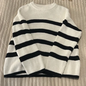 Randig stickad tröja från Selected Femme - Säljer en snygg stickad tröja från Selected Femme med breda svarta och vita ränder. Tröjan har rund halsringning, lång ärm och en loose fit. Perfekt för dig som gillar en klassisk men trendig look. Inte alls kommit till användning 