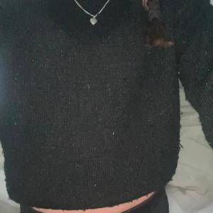 Svart stickad tröja med loose fit - En svart stickad tröja med avslappnad passform och långa ärmar. Tröjan har en enkel design utan synliga detaljer och är perfekt för dig som gillar en basic och stilren look. Passar bra till jeans eller kjol för en chill vibe.