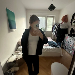 Svart teddyjacka med knappar - Mysig svart teddyjacka med stora knappar framtill och klassisk krage. Jackan har en loose passform och är perfekt för dig som gillar en chill och trendig look. Passar till allt och är superenkel att styla med både jeans och leggings. 140 fast passar mig med xs