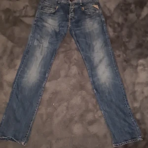 Blå Replay jeans straight fit 31/34 - Säljer ett par klassiska blå jeans från Replay i rak modell. Jeansen har snygga slitningar och tvättade detaljer.