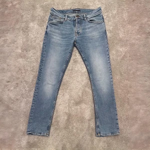 Nudie Jeans - Säljer ett par ljusblå jeans från Nudie i storlek 30/30. De har en klassisk femficksdesign och är i extremt bra skick utan defekter. Perfekta för både vardag och fest! Fraktar på köparens bekostnad samma dag som beställning. 