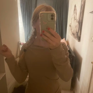 Beige långärmad tröja  - Säljer en beige långärmad tröja med snygg snörningsdetalj på sidan. Tröjan har en loose passform och är tillverkad i mjuk bomull. Perfekt för dig som gillar en enkel men trendig stil. Passar till både jeans och kjol. Og pris: 200