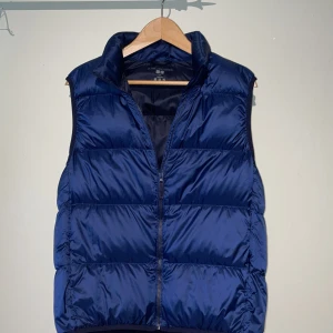 Mörkblå dunväst från Uniqlo - Säljer just nu en mörkblå dunväst från Uniqlo i storlek S. Västen är ultralätt och är i mycket bra skick. Perfekt för kyliga dagar när du vill hålla värmen utan att känna dig tung. Pris 199, nypris 450