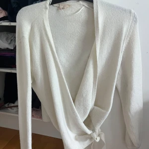 Vit omlottkofta  - Superfin vit omlottkofta från Pernilla Wahlgren. Koftan har långa ärmar och knyt i midjan för en snygg passform. Perfekt att slänga på sig över ett linne eller t-shirt. Mjuk och skön stickad känsla. Storlek XS aldrig använd 🥰🥰