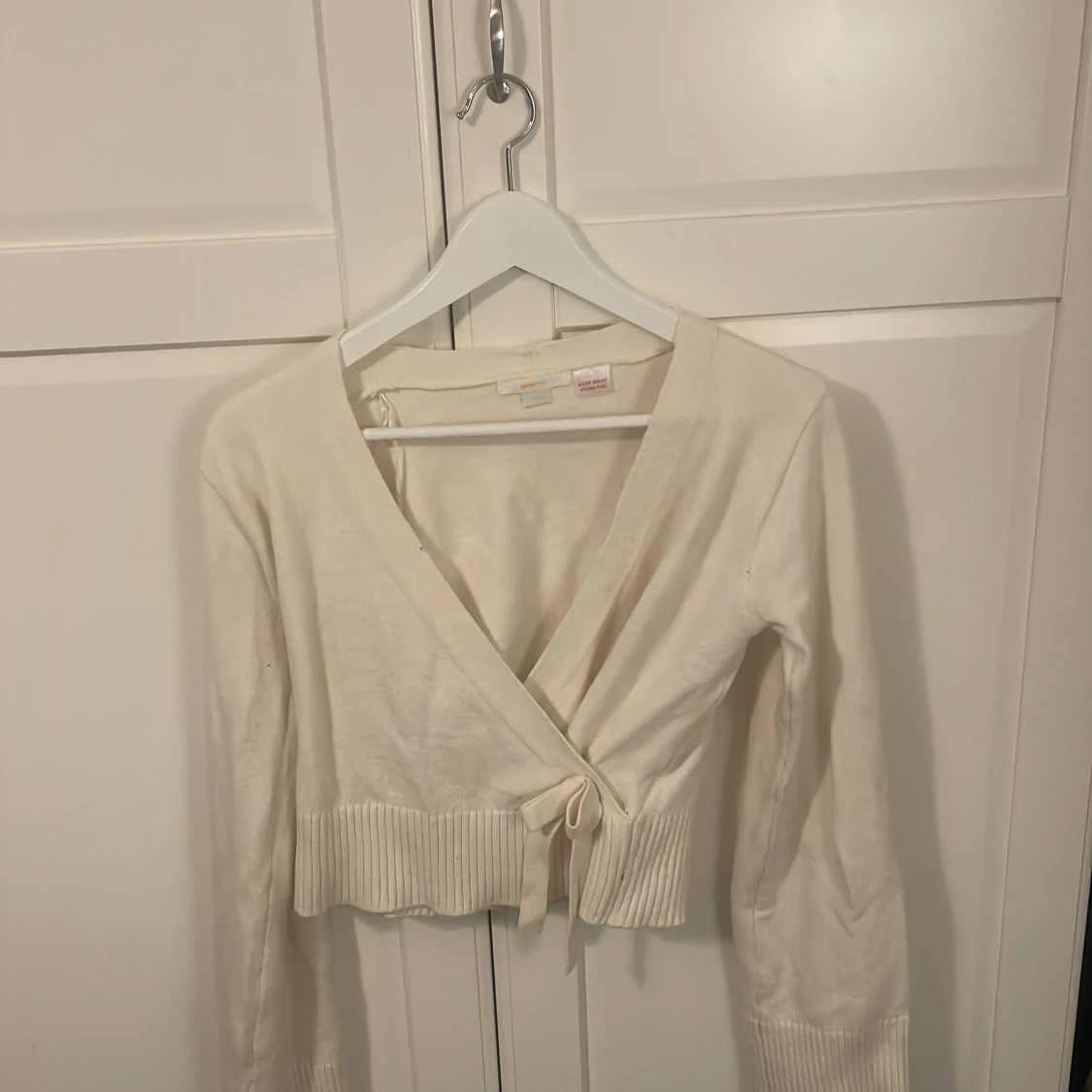 Vit omlottkofta med knyt och ribbad kant