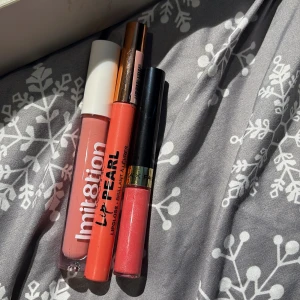 Tre läppglans i rosa och korall - Säljer tre snygga läppglans i olika nyanser: ett från Imitation i ljusrosa, ett korallfärgat Lip Pearl och ett glittrigt rosa från Max Factor. Perfekta för att ge läpparna glans och färg. Smidiga att ta med i väskan.