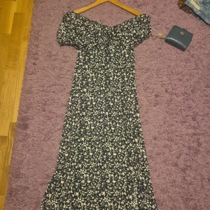 Blommig offshoulder långklänning - Supersöt långklänning från Shopping Shop i svart och vitt med blommigt mönster. Offshoulder-modell med korta puffärmar och flowy passform. Perfekt för dig som gillar romantiska vibes och vill sticka ut lite extra. Tunn och luftig, passar perfekt till varma dagar. Har inte haft på mig den många gånger. Kom gärna med prisförslag 