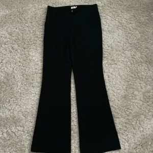 Svarta bootcut kostymbyxor Nelly - Säljer ett par svarta bootcut byxor från Nelly i storlek 34. Byxorna har låg midja och klassisk bootcut passform med lätt utsvängda ben. De är försmå för mig som har oftast s.