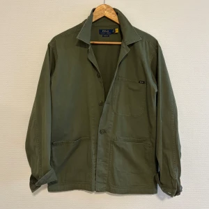 Overshirt/ Fieldjacket från Polo Ralph Lauren - Snygg olivgrön overshirt från Polo Ralph Lauren i klassisk passform. Nypris 2000 kr. I princip oanvänd.