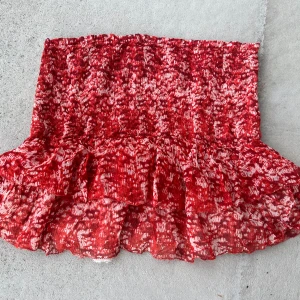 Kjol Isabel Marant - Supersöt kort kjol i rött/orange med smockad midja och volangkant. Från Isabel Marant étolie, storlek 36.