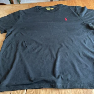 Svart T-shirt från Polo Ralph Lauren – Storlek S - En klassisk svart t-shirt från Polo Ralph Lauren i storlek S. Bekväm och stilren, perfekt för alla tillfällen. I mycket bra skick.  