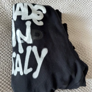 Svart hoodie från Dondup med tryck - Cool svart hoodie från Dondup med vit graffiti-inspirerad text 'Made in Italy' på bröstet.