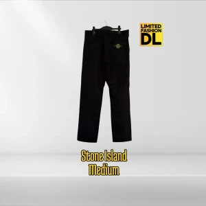 Stone Island Cargo Byxor - Svarta byxor från Stone Island med klassisk patch på bakfickan. Byxorna har raka ben, normal passform och är tillverkade i bomull. Snygg minimalistisk look med diskreta sömdetaljer och dragkedja i midjan. Perfekta för en clean och stilren outfit. Storlek M, passar 175-185 cm. Aldrig använda.