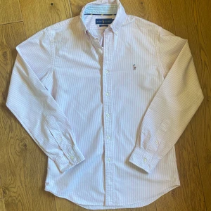 Ralph Lauren skjorta - Rosa och vitrandig Ralph Lauren skjorta Inga defekter, 10/10 skick Perfekt inför sommaren Storlek S, passar dig som vanligtvis bär storlek S och M. Kom gärna med frågor eller prisförslag!