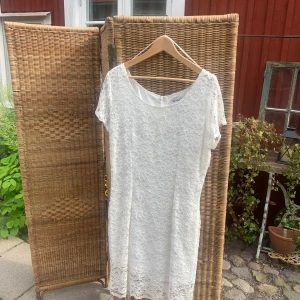 Vit spetsklänning från Camera - Superfin vit kortklänning från Camera med spets över hela klänningen och rund halsringning. Klänningen har korta ärmar, dragkedja i ryggen och är fodrad för extra komfort. Perfekt för sommarens alla tillfällen!
