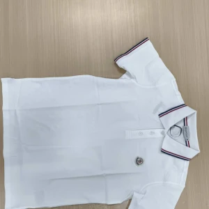 Vit Moncler pikétröja  - Vi kan prata om priset om du är seriöst intresserad. Vit pikétröja från Moncler med klassisk krage och knäppning framtill. Kragen och ärmsluten har snygga ränder i rött och marinblått. Tröjan har Moncler-logga på bröstet och är tillverkad i mjuk bomull. Perfekt för en clean och sportig look. Den är storlek M men är lite mindre så ungefär typ S tvättade den några gången för att försöka krympa den men den passade inte mig.