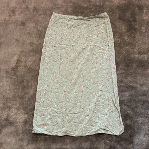 Kjol från Brandy Melville - Kjol från Brandy Melville. Kjolen är mellan lång, är i blom mönster och har en dragkedja och slits.