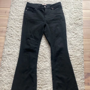 Svarta bootcut jeans från Vero Moda - Svarta jeans från Vero Moda med bootcut-modell och klassisk femficksdesign. Byxorna är i storlek L och i längden 30 och är tillverkade i en mjuk blandning av modal och bomull, vilket gör dem riktigt sköna. Perfekta för dig som gillar en tidlös look med lite utsvängda ben. Jeansen kostar 60€/600 kronor nytt pris.