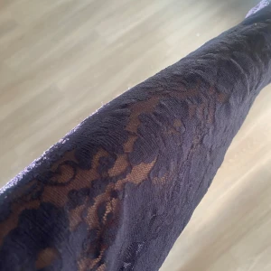 Mörkblå topp med spetsärmar - Supersnygg mörkblå topp från H&M med långa spetsärmar och spetsdetaljer över axlarna. Tight passform och rund halsringning. Perfekt för dig som gillar en stilren look med lite extra detaljer.