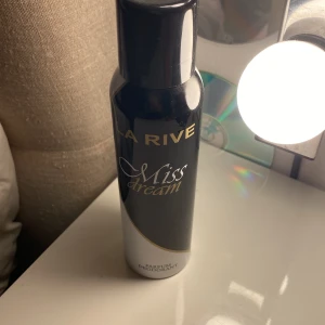 La Rive Miss Dream Parfymdeodorant - En stilren parfymdeodorant från La Rive i svart och silver design. Flaskan har en elegant form och text i guld och vitt. Perfekt för dig som vill ha en fräsch och feminin doft i vardagen.