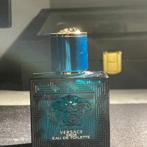 Versace Eros Eau de Toilette 30ml - Versace Eros Eau de Toilette i en lyxig, turkosblå glasflaska med guldiga detaljer och Medusa-huvudet på framsidan. Flaskan har en stilren, fyrkantig form och kommer med originalkartong i matchande färg. En ikonisk doft för dig som gillar exklusiva parfymer. Perfekt vardaglig doft och exeptionell nu till sommaren. Parfymen är dessvärre lite använd (4 ml) men bör ej vara ett problem. Priset är ej hugget i sten 🫡💯