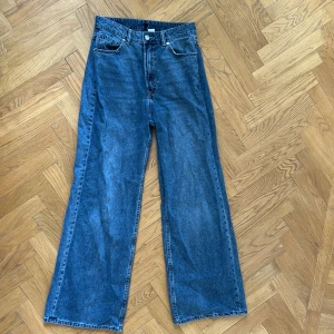 Blå wide jeans med hög midja - Säljer ett par blå baggy/vida jeans från HM. Är väl använda och har inga defekter förutom ett litet hål som knappast syns på ena benet(se bild 4). Jeansen är i denim och har en snygg vintagekänsla. Älskar de men säljer då de inte längre passar mig. 
