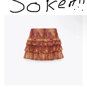 Färgglad volangkjol med mönster - Superfin kort kjol med flera volanger i rött, gult och rosa. Kjolen har ett bohemiskt mönster och smock i midjan för skön passform. Perfekt för dig som gillar färg och vill sticka ut lite extra.