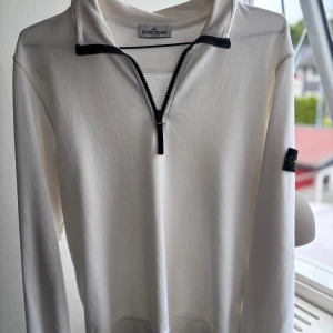 Vit half zip tröja från Stone Island - Hej! Säljer nu min Stone island half zip i junior strl pågrund av att jag har växt ur den! Är i fint skick med mindre tecken på användning, köpt på hemsidan miinto!  Hör av dig för fler frågor/skickar gärna fler bilder ifall begärts😃