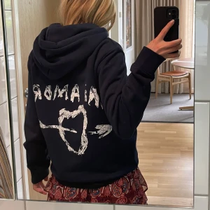 Mörkblå hoodie med tryck från MIRA PARIS - Säljer en mörkblå hoodie med ett tryck på ryggen. Tröjan har en stor ficka framtill och justerbar huva. Är helt slutsålt och har använt ett fåtal gånger, den har inga defekter! Köpte för 1700kr.