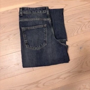 Mörkblåa wide jeans med loose fit - Säljer ett par mörkblåa jeans med breda ben och loose fit. Jeansen har klassisk femficksdesign, hög midja och är tillverkade i kraftigt denimtyg. Perfekta för dig som gillar en avslappnad och trendig stil.