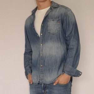 Replay Jeansskjorta  - REPLAY JEANSSKJORTA  Storlek : L  Passform : Normal  Användning : Väldigt fint skick utan defekter  Nypris : Cirka 1200SEK  Modellen på bilden är 182CM och väger 80KG